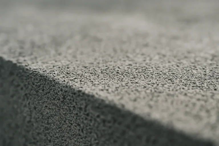 Gros plan sur la texture d'une surface en béton poreuse, éclairage doux